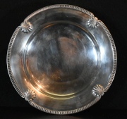 Masitero circular de metal plateado europeo, con motivos de conchillas. Dim. 24 cm. -80-