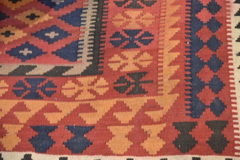 Carpeta Kilim de lana con motivos geomtricos. 3 franjas en la guarda, azul, rojo y naranja. Mide 285 x 195. Desgastes