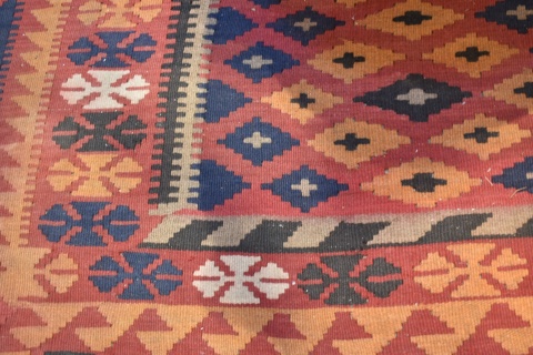 Carpeta Kilim de lana con motivos geomtricos. 3 franjas en la guarda, azul, rojo y naranja. Mide 285 x 195. Desgastes