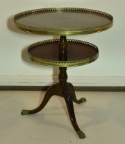 Mesa circular de dos planos; de caoba. Regatones y barandas caladas de bronce dorado. Alto 74 cm. Dim. mayor 64 cm