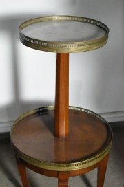 Mesa circular de dos planos con tapa de mrmol. Bordes con galera de bronce.  Dimetro mayor 41 cm.  Alto 80 cm.