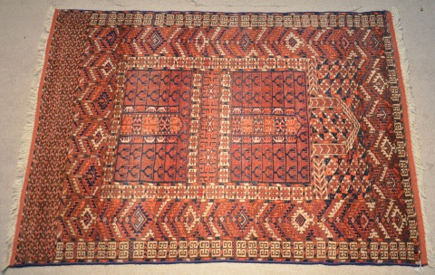 Alfombra turcomana de lana. Dos rectangulos y grandes guardas sobre fondo bord. 140 x 111 cm