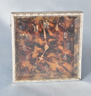 Pequeo reloj cuadrangular sobre simil carey (833) 8 x 8 cm.