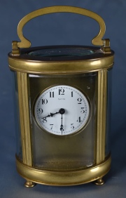 CARRIAGE CLOCK BLACK, caja de bronce dorado de seccin oval, con manija superior.