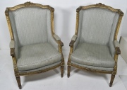 Dos Sillones bergere, estilo Luis XVI, tapizado celeste con tachas y almohadones. Pequea restauracin.
