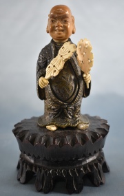 Pequea figura de chino en bronce con palmetas en la mano. 18 cm.
