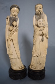 FIGURA CON FLORES y FIGURA CON ABANICO, dos tallas chinas de marfil. Atrs firmadas en rojo. Bases de madera. Alto: 35cm