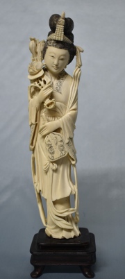 Dama con flor de loto, marfil, base de madera. Alto total: 29,5 cm.