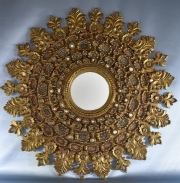 ESPEJO PERUANO DE ESTILO COLONIAL, de madera tallada y dorada con decoracin de flores.Dimetro total: 74 cm.