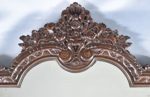 ESPEJO DE PARED, con marco de madera tallada. Cresta irregular con decoracin vegetal. Mide: 80 x 75 cm.