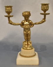 CANDELABRO DE BRONCE, en forma de Fauno, quien sostiene dos brazos. Base de mrmol. Alto total: 19 cm.