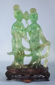 DAMAS PORTANDO ATRIBUTOS, figura de raz de esmeralda tallada con base de madera. Alto total: 19,2 cm.