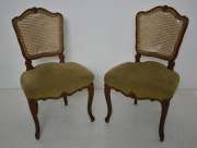 PAR DE SILLAS ESTILO LUIS XV, de nogal tallado, respaldos esterillados, averas, asiento tapizado en tela beige.