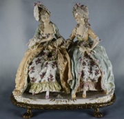 Grupo dos figuras femeninas de porcelana policromada. Restaurado. Fisuras. Alto: 26 cm. Frente: 26 cm.
