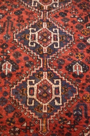 ALFOMBRA SHIRVAN, de lana. Profusa ornamentacin de motivos florales sobre fondo bordo en el centro y azul en el resto.