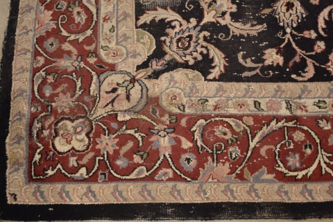 ALFOMBRA PERSA, de lana, de fondo negro con profusa ornamentacin de motivos florales policromos estilizados. Desgastes
