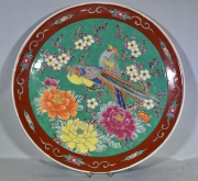 PLATO JAPONES, de porcelana recubierta de esmaltes polcromos con decoracin de aves y flores. Fisura. Dimetro: 34 cm.