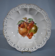 CENTRO DE BAVARIA, de porcelana alemana con decoracin de frutos polcromos. Borde lobulado y calado. Dimetro: 23 cm.