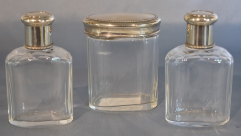 Tres piezas de toilette, 2 perfumeros con tapa y un frasco con tapa plata.Alto: 10 y 9 cm.