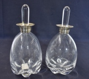 Dos botellones con tapón, uno cascado, golletes de plata. 23 cm.