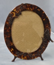 Portarretrato oval, de carey con pájaro sobre rameados. Alto: 25 cm.