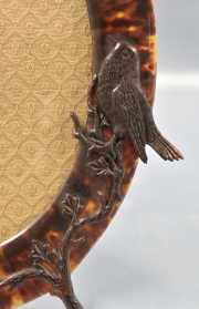 Portarretrato oval, de carey con pájaro sobre rameados. Alto: 25 cm.