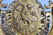 CHARITATE PERFECTA, emblema procesional de metal dorado y labrado. Escudo central con un ave y pichones. Frente 39 cm