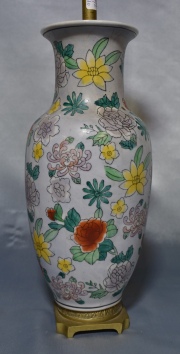 LAMPARA ORIENTAL, de porcelana en forma de balaustre con ornato de flores y hojas polícromas. Base de bronce dorado. Alt